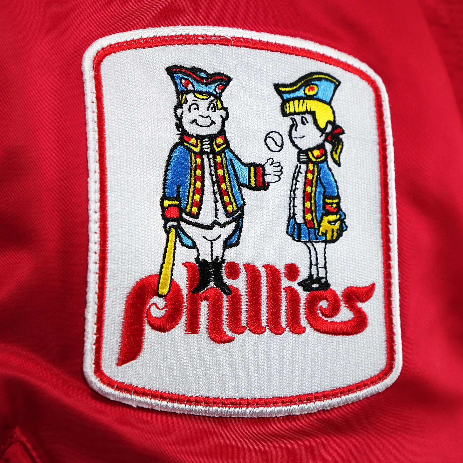 The Phillies Quakers Logo on the Philadelphia Phillies MLB Patch Alpha Industries Reversible Bomber Jacket With Camo Liner | Red Bomber Jacket
