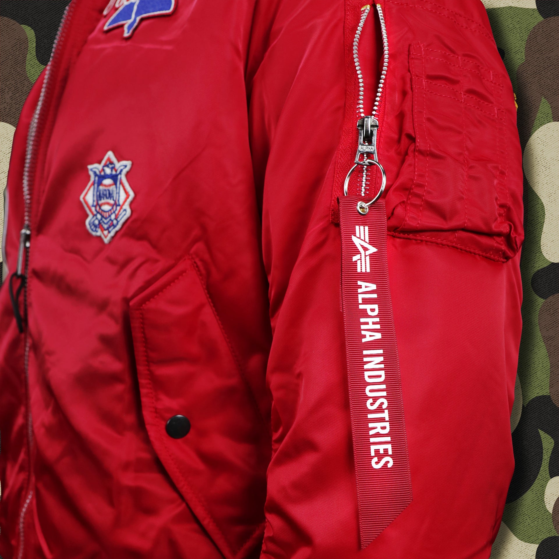 The Alpha Industries Flight Safety Tag on the Philadelphia Phillies MLB Patch Alpha Industries Reversible Bomber Jacket With Camo Liner | Red Bomber Jacket