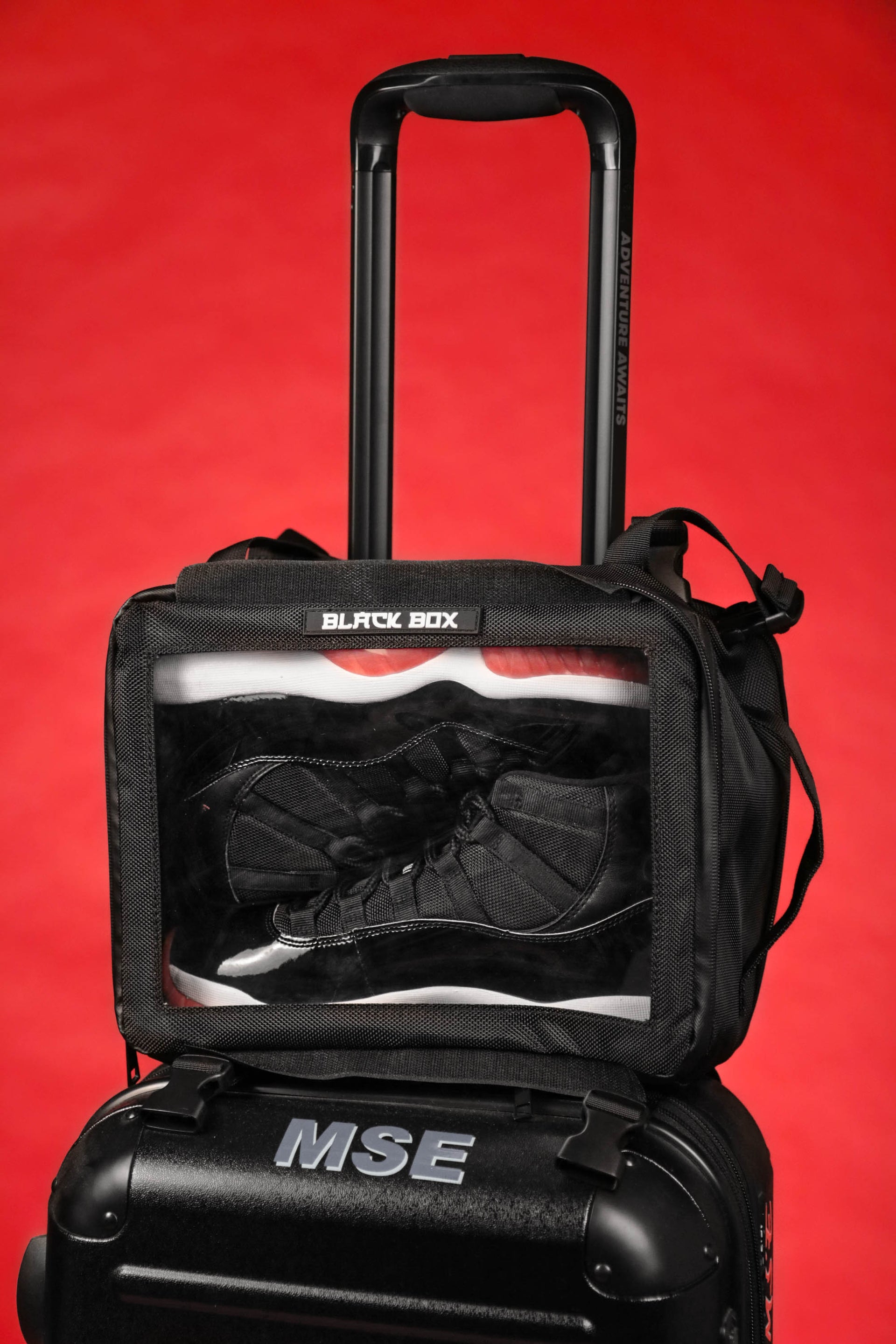 The Black Box Portable Hanging Sneaker Bag For Travel and Storage With Clear Window on a suitcase
