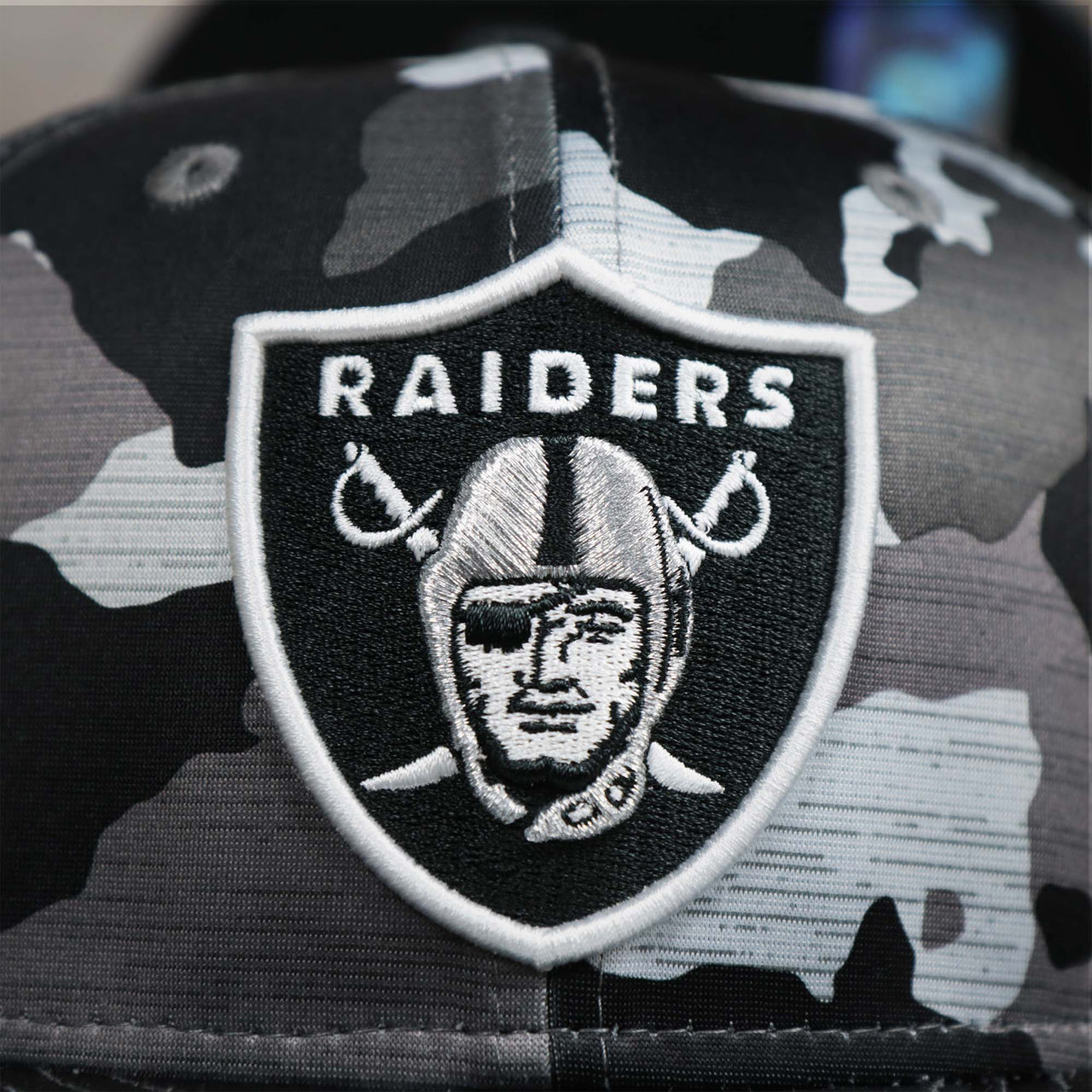 The Raiders Logo on the Los Angeles Raiders NFL OnField Summer Training 2022 Camo 9Fifty Snapback | Black Camo 9Fifty