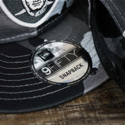 The 9Fifty Sticker on the Los Angeles Raiders NFL OnField Summer Training 2022 Camo 9Fifty Snapback | Black Camo 9Fifty