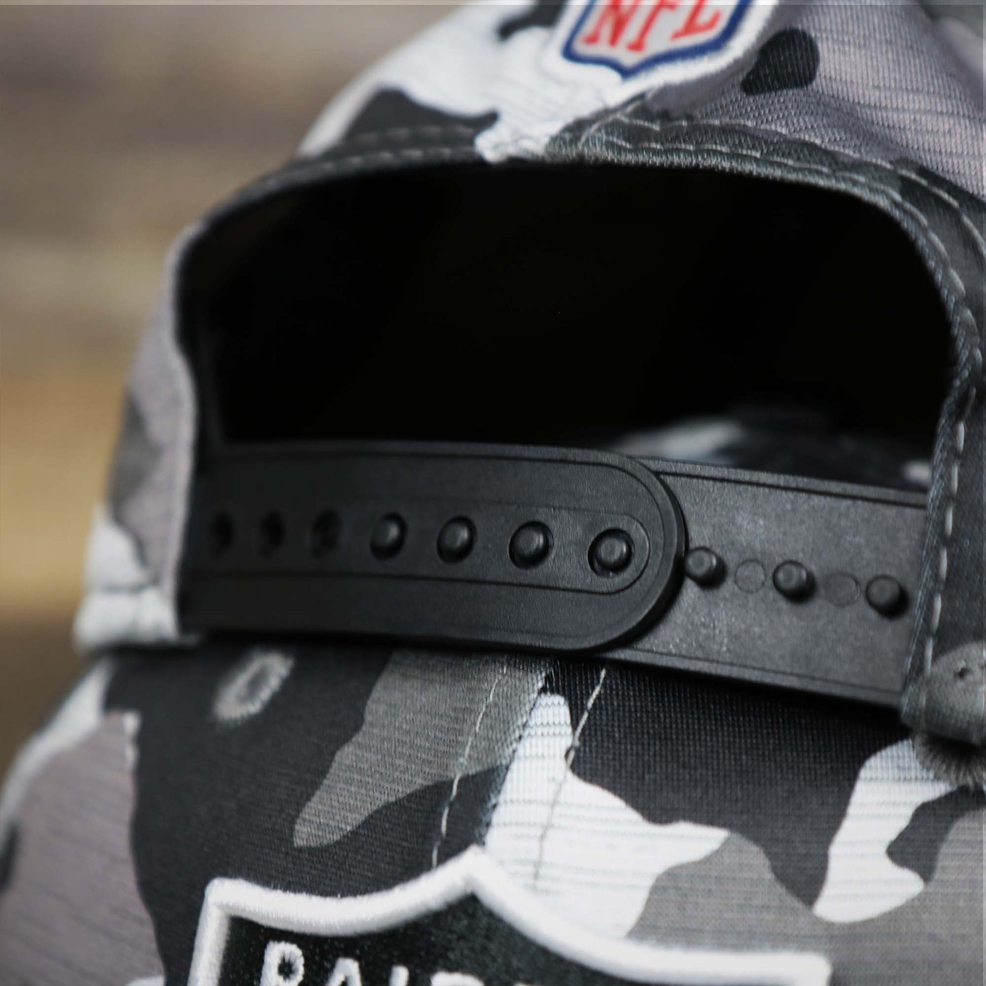 The adjustable strap on the Los Angeles Raiders NFL OnField Summer Training 2022 Camo 9Fifty Snapback | Black Camo 9Fifty