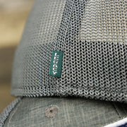 The Green Legacy Tag on the OCNJ Ocean City 1879 Sunset Wave Logo Mesh Stretch FIt Hat | Dark Green And Dark Grey Stretch Fit Hat
