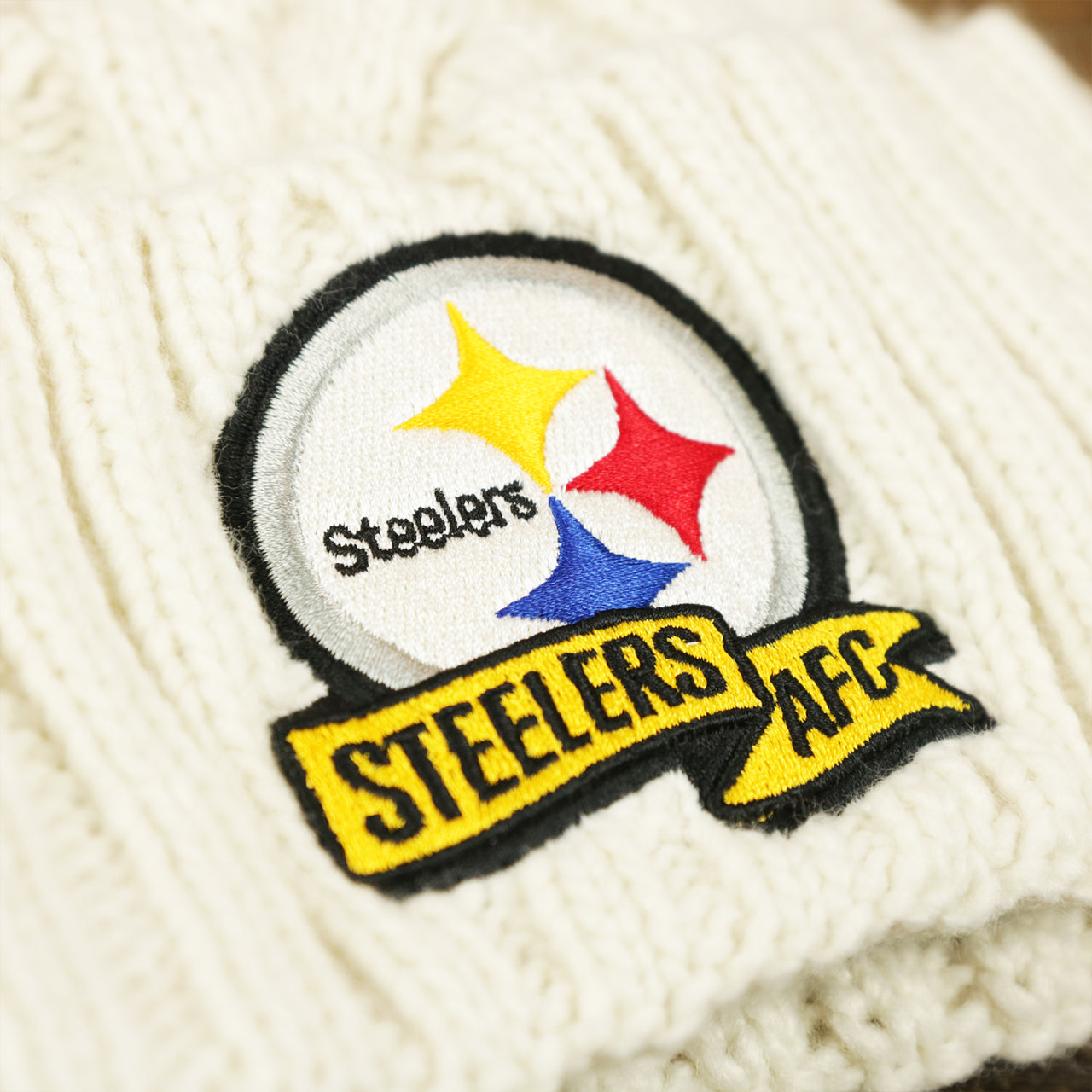 The Steelers AFC Banner on the Kid's Philadelphia Steelers 2022 AFC Cuffed Winter Knit Meeko Pom Pom Beanie | Kid's White Winter Beanies