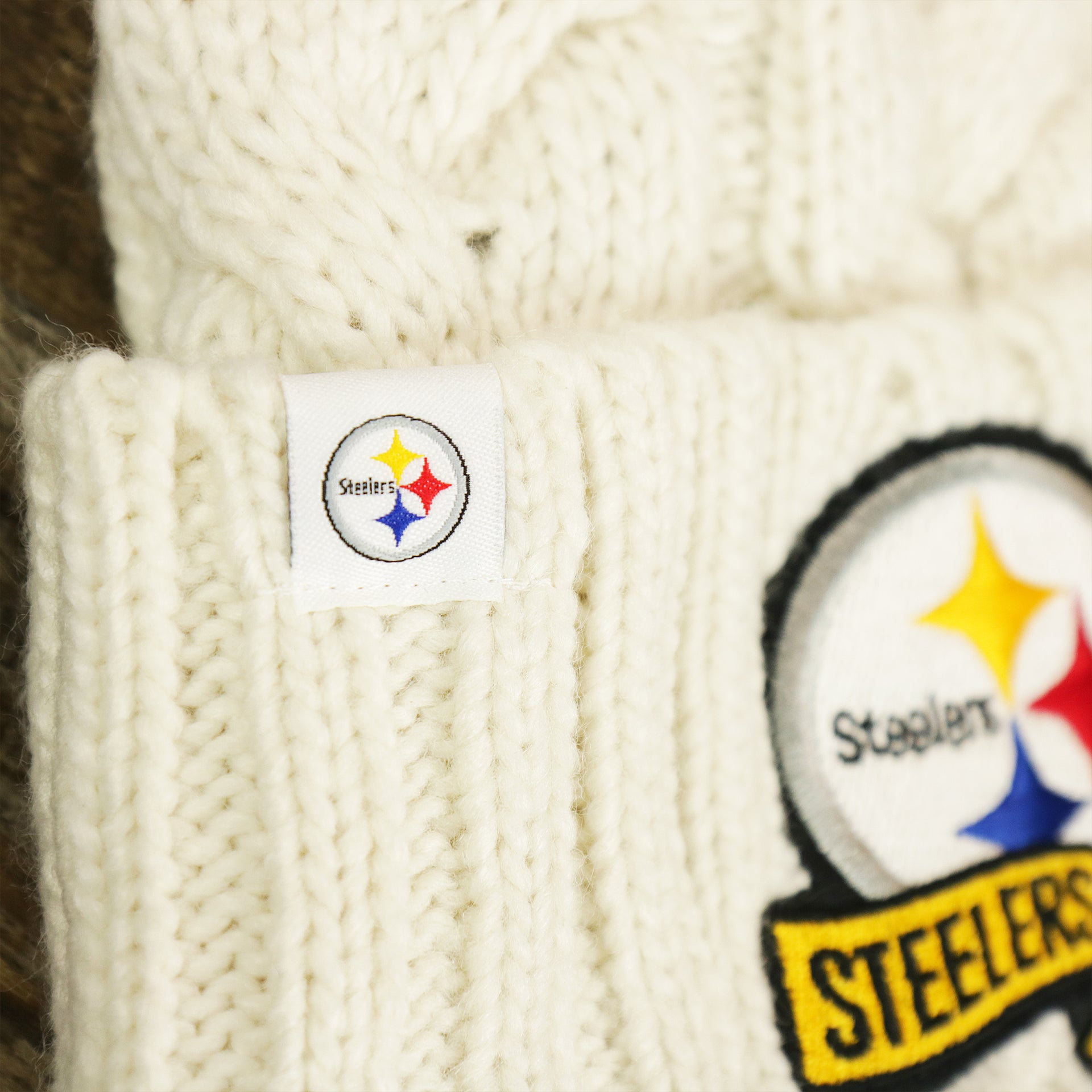 The Steelers Tag on the Youth Philadelphia Steelers 2022 AFC Cuffed Winter Knit Meeko Pom Pom Beanie | Youth White Winter Beanies