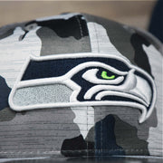 The Seahawks Logo on the Seattle Seahawks NFL OnField Summer Training 2022 Camo 9Fifty Snapback | Navy Blue Camo 9Fifty