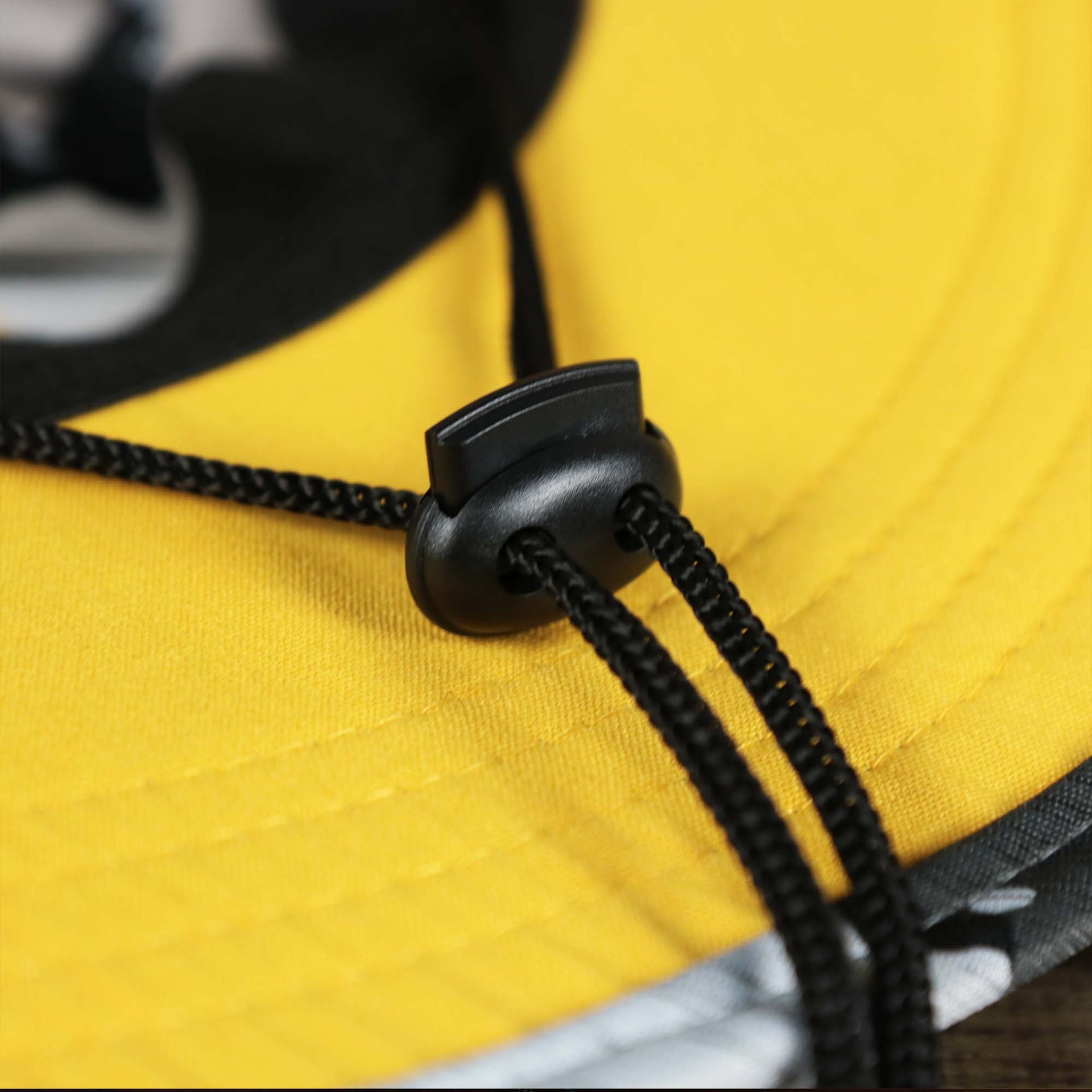 The Adjustable Chin Strap on the Pittsburgh Steelers NFL Summer Training Camp 2022 Camo Bucket Hat | Yellow Bucket Hat