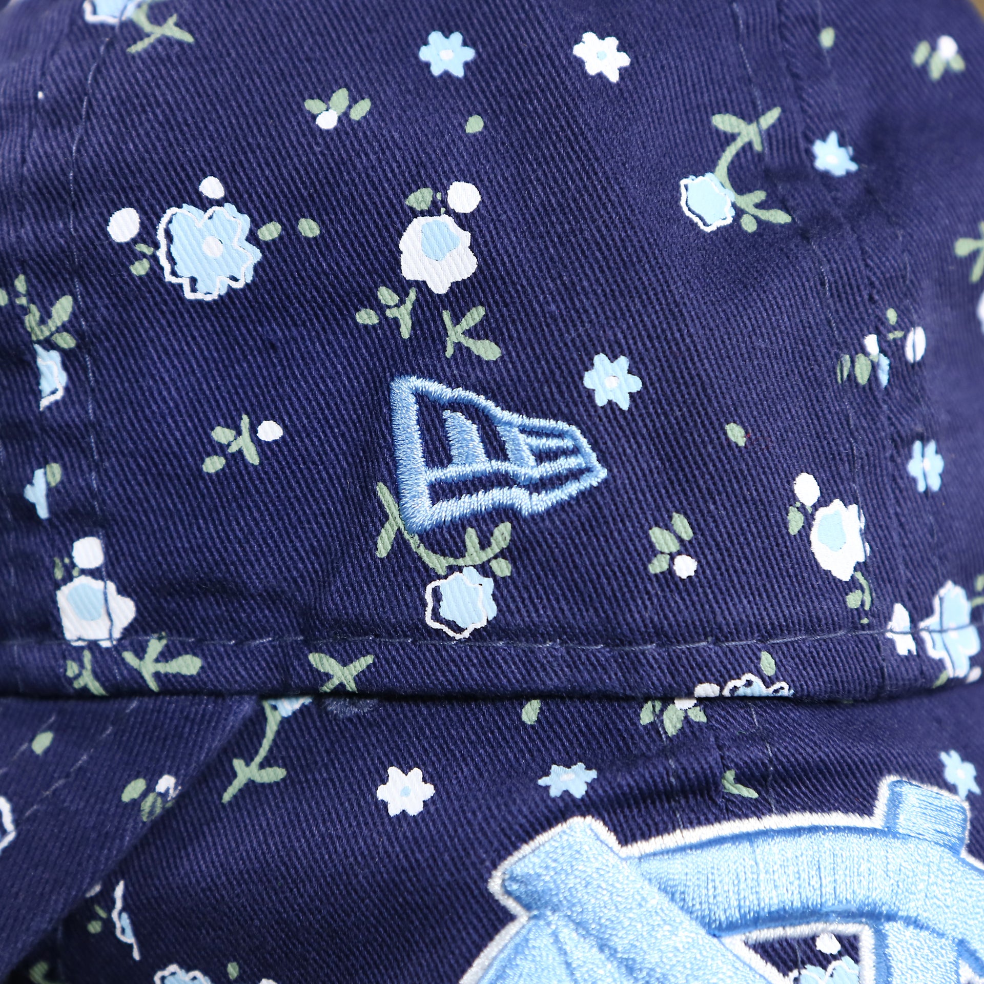 The New Era Logo on the Women’s North Carolina Tar Heels All Over Micro Floral Print 9Twenty Dad hat | Navy Blue 9Twenty Hat