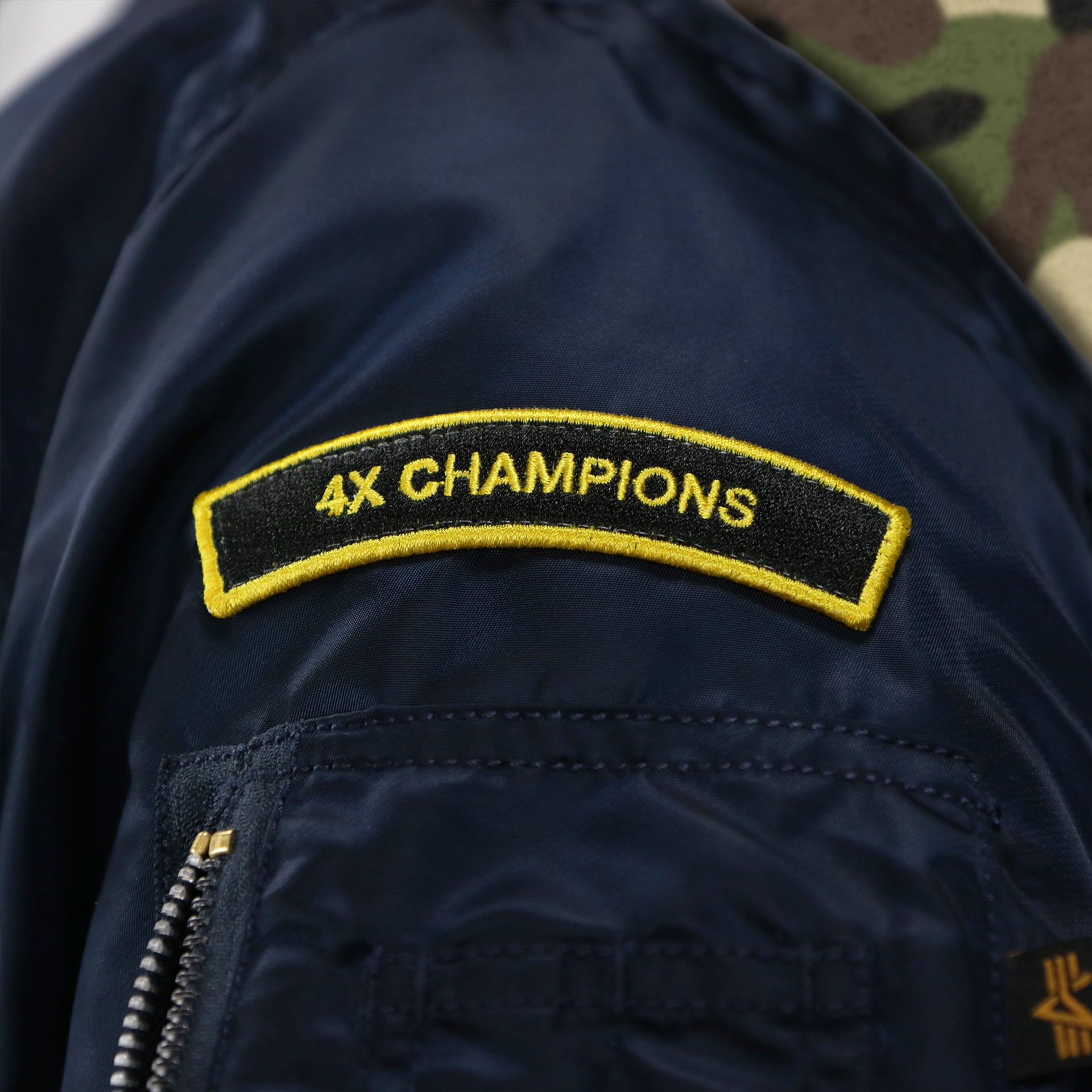 The 4x Champions on the Detroit Tigers MLB Patch Alpha Industries Reversible Bomber Jacket With Camo Liner | Navy Blue Bomber Jacket