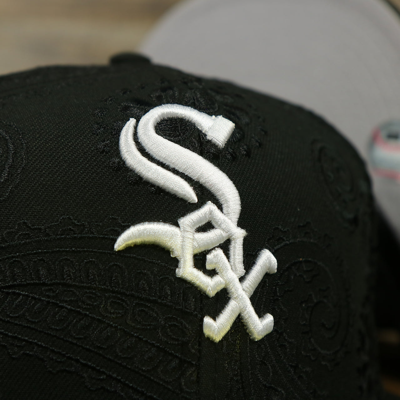 Close up of the White Sox logo on the Chicago White Sox Paisley Bandana Print Embroidered 59Fifty Fitted Cap | New Era MLB Swirl 5950