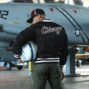 The backside of the Chicago White Sox MLB Patch Alpha Industries Reversible Bomber Jacket With Camo Liner | Black Bomber Jacket with a matching helmet