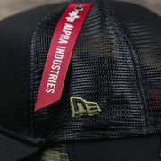 The New Era Logo on the New York Yankees Alpha Industries Flying A Mesh Print 9Forty Trucker Hat With Flight Tag | Black Trucker Hat