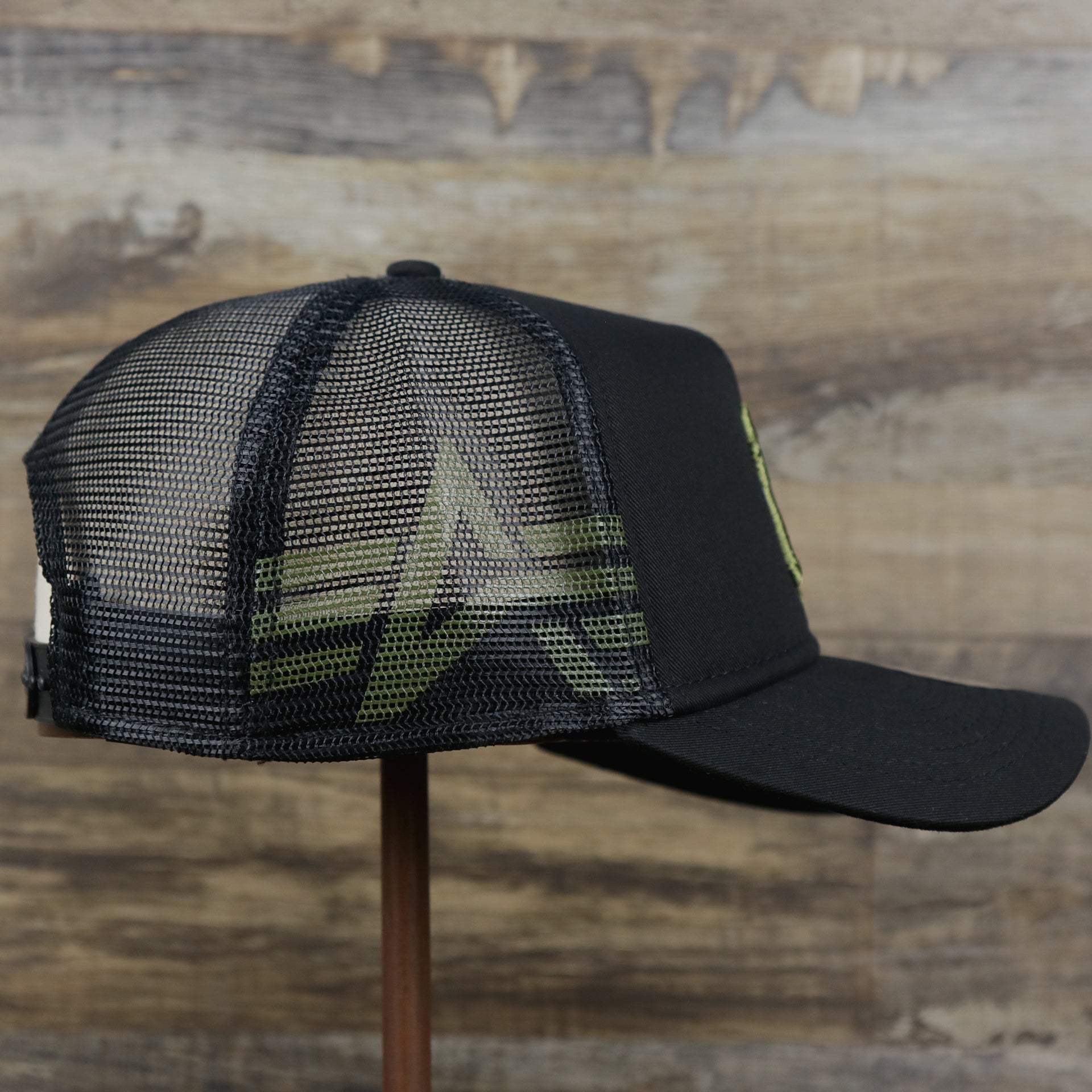 The wearer's right on the New York Yankees Alpha Industries Flying A Mesh Print 9Forty Trucker Hat With Flight Tag | Black Trucker Hat