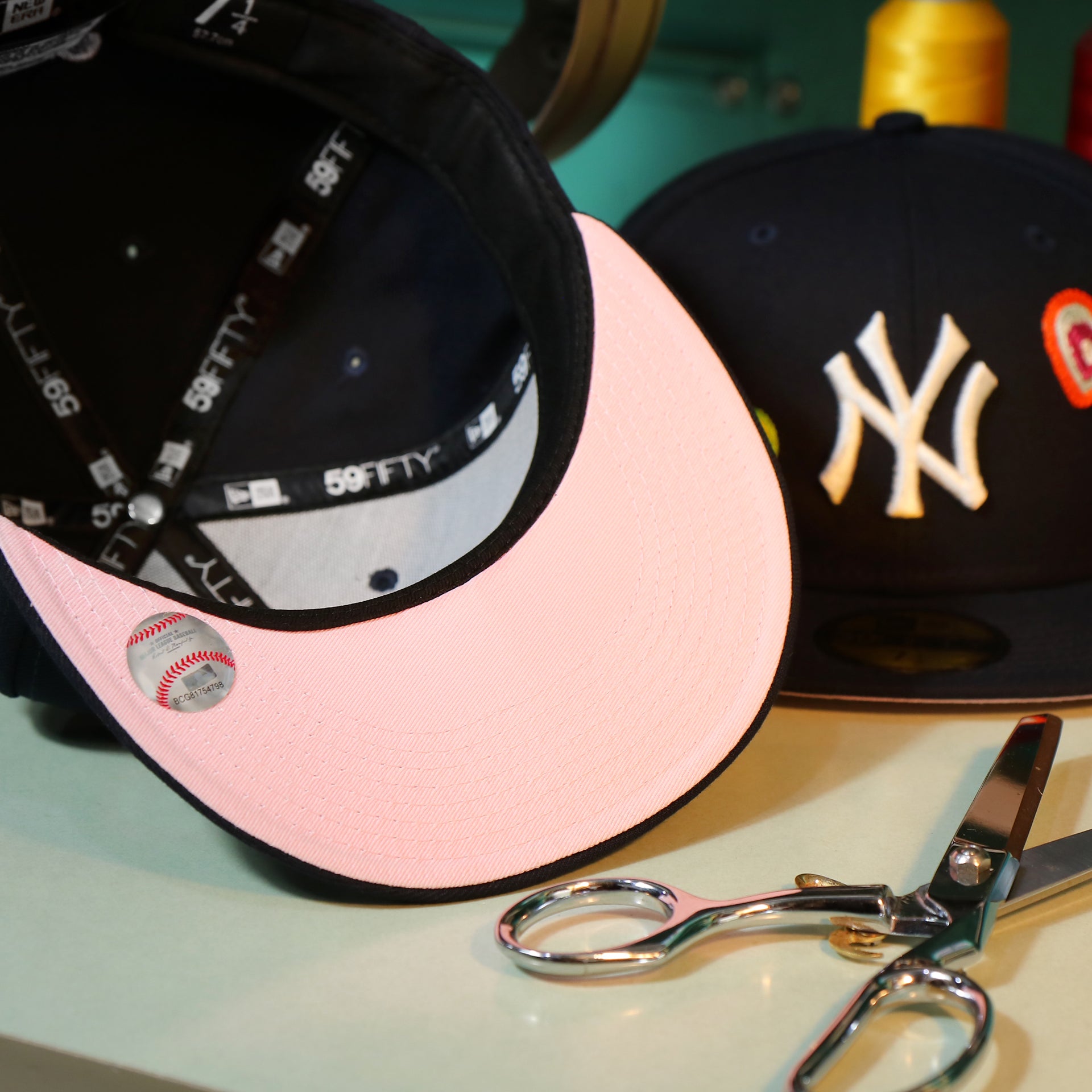 Pink under visor of the New York Yankees All Over Embroidered Chain Stitch Heart Pink Bottom 59Fifty Fitted Cap | Navy 59Fifty Cap