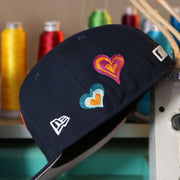 Wearer's left of the New York Yankees All Over Embroidered Chain Stitch Heart Pink Bottom 59Fifty Fitted Cap | Navy 59Fifty Cap