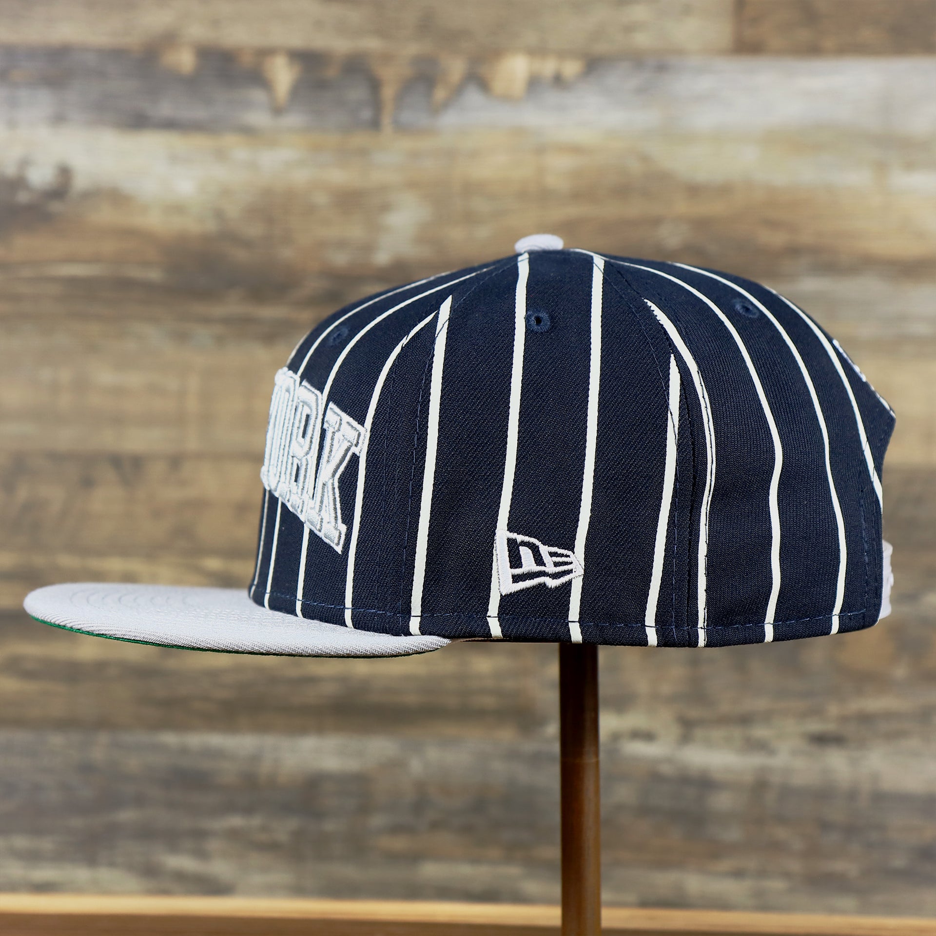 The wearer's left of the New York Yankees City Arch Striped 9Fifty Snapback Cap | Pin Stripe 9Fifty Cap