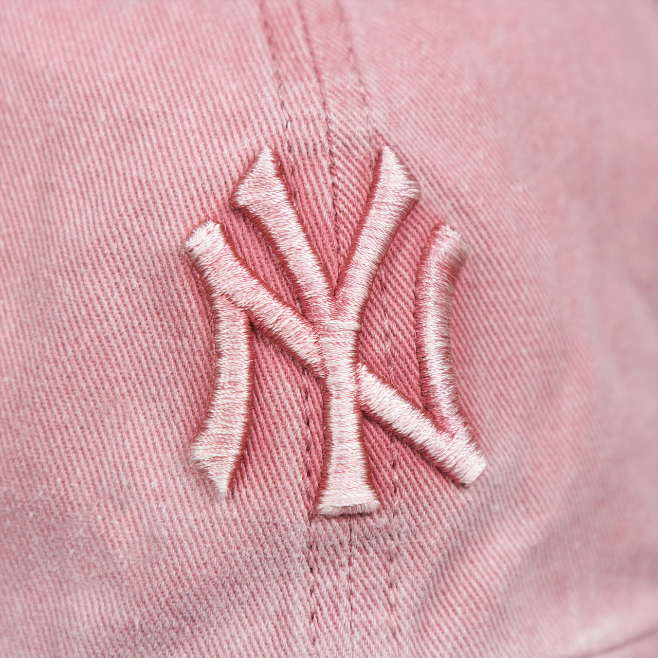 The Yankees Logo on the Women’s New York Yankees Gray Bottom Vintage Washed Dad Hat | Vintage Pink Women’s Dad Hat