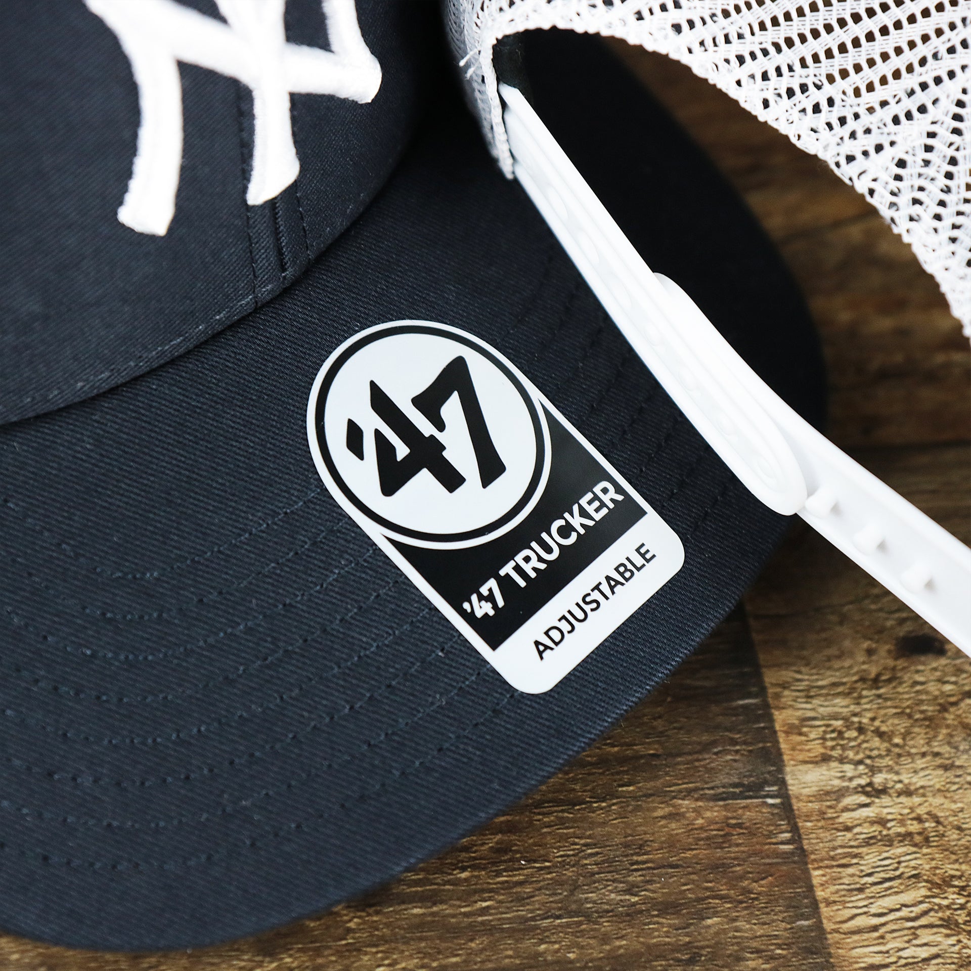 The 47 Brand Trucker Sticker on the New York Yankees Mesh Back Gray Bottom Trucker Hat | Navy Blue Dad Hat