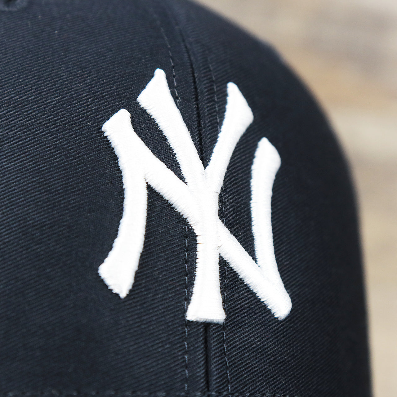 The Yankees Logo on the New York Yankees Mesh Back Gray Bottom Trucker Hat | Navy Blue Dad Hat