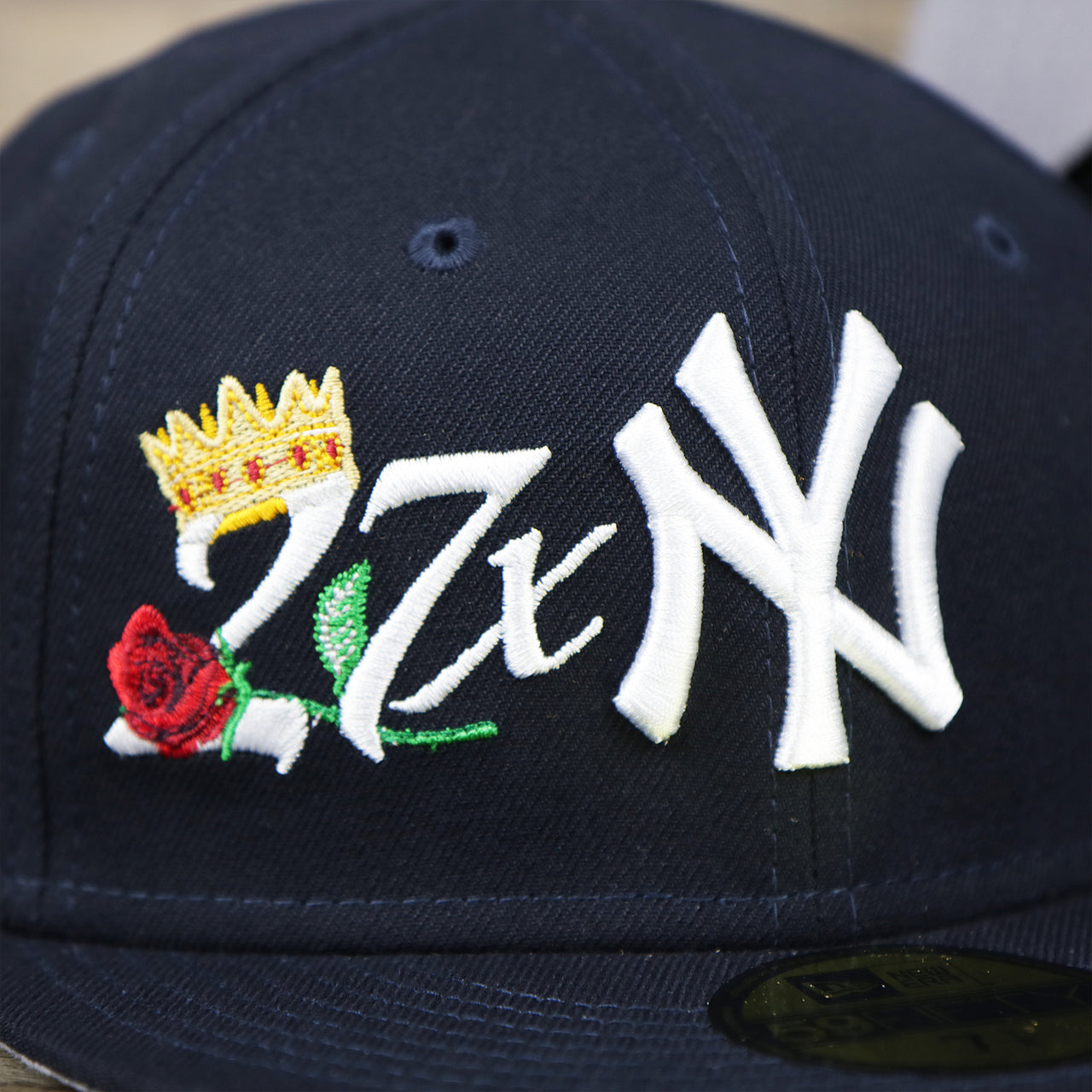 The Yankees Crown Champs logo on the New York Yankees Crown Champions Gray Bottom World Championship Wins Embroidered Fitted Cap | Navy Blue 59Fifty Cap