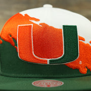 front of the University of Miami Vintage Retro NCAA Paintbrush Mitchell and Ness Snapback Hat | Orange/Green/White