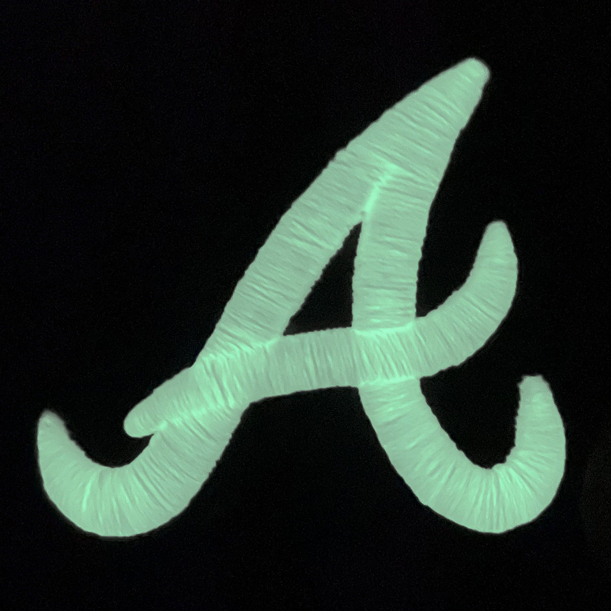 Braves logo glowing in the dark on the Atlanta Braves Glow In The Dark 1995 World Series Peach Bottom 59Fifty Side Patch Fitted Cap