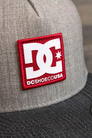 the 2-Tone Gray Snapback Skater Hat | DC Shoes Black Bottom Snap Back Cap has a sewn red patch on the front with the DC logo