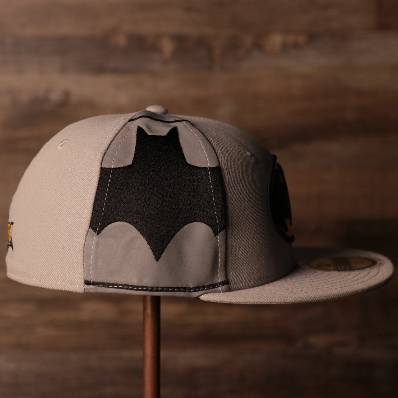 the wearers right side has a reflective panel with the batman logo enlarged on it Batman Grey Bottom Fitted Cap | Batman Superhero Gray Bottom Fitted Hat
