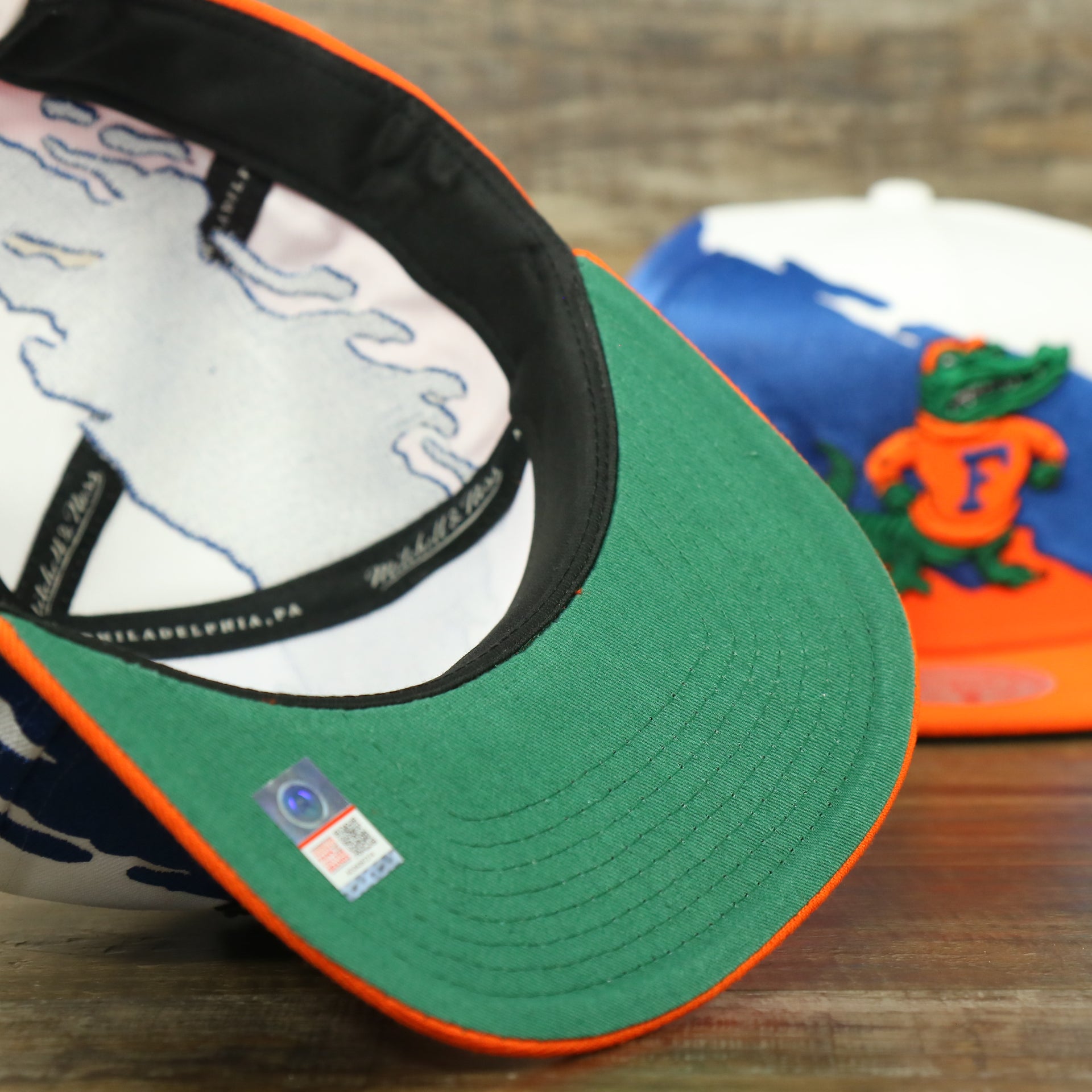 bottom of the University of Florida Vintage Retro NCAA Paintbrush Mitchell and Ness Snapback Hat | Orange/Blue/White