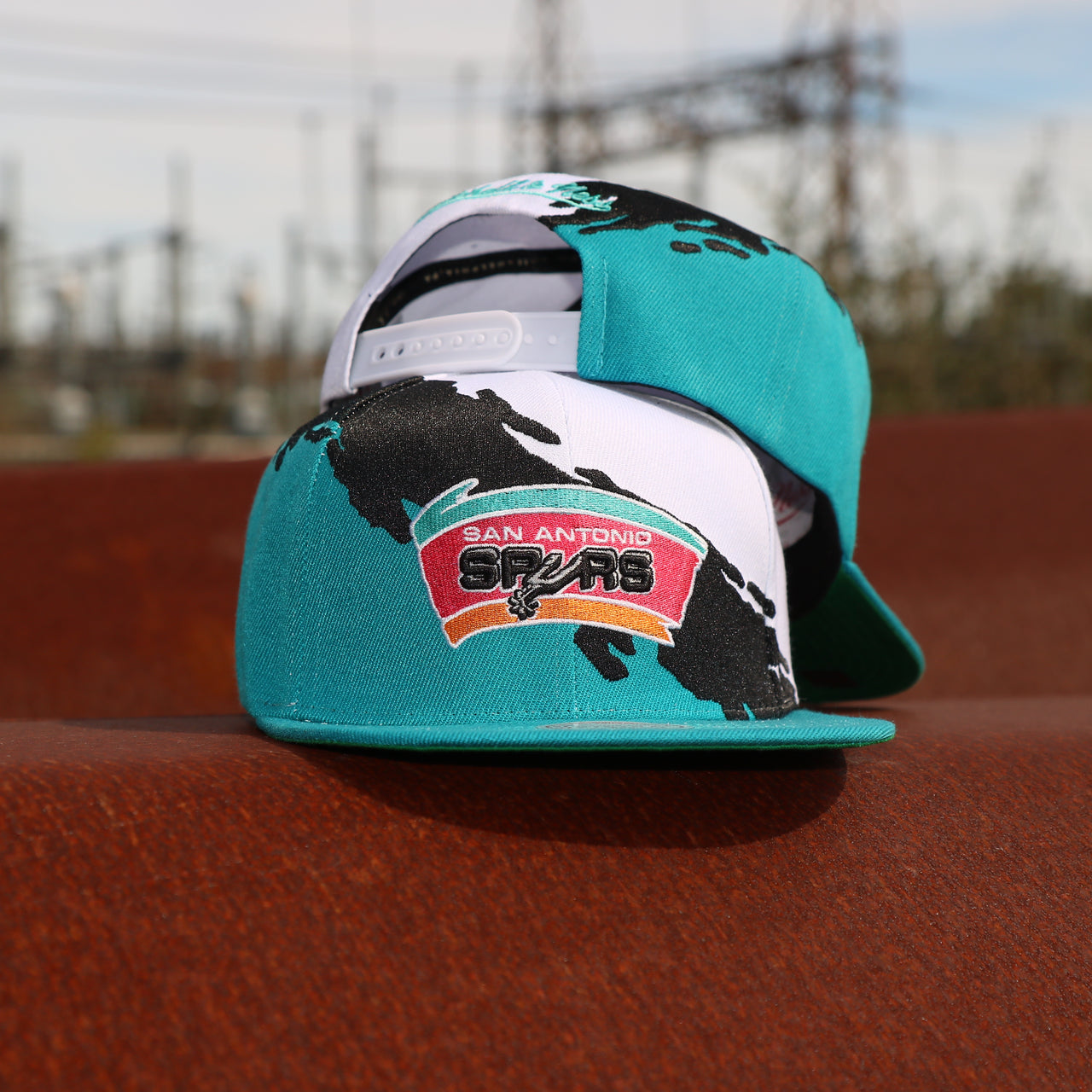 front and back of the San Antonio Spurs Vintage Retro NBA Paintbrush Mitchell and Ness Snapback Hat | Teal/White/Black