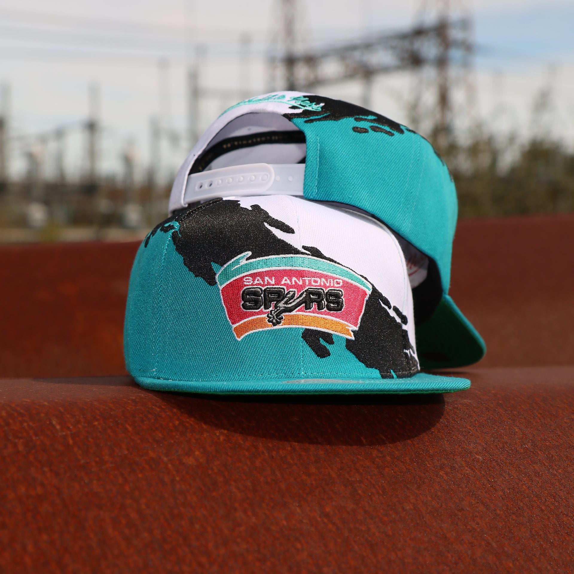 front and back of the San Antonio Spurs Vintage Retro NBA Paintbrush Mitchell and Ness Snapback Hat | Teal/White/Black