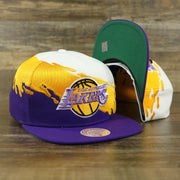 front and bottom of the Los Angeles Lakers Vintage Retro NBA Paintbrush Mitchell and Ness Snapback Hat | Purple/White/Yellow