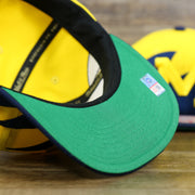 green bottom on the University of Michigan Vintage Retro NCAA Sharktooth Mitchell and Ness Snapback Hat | Yellow/Navy Blue