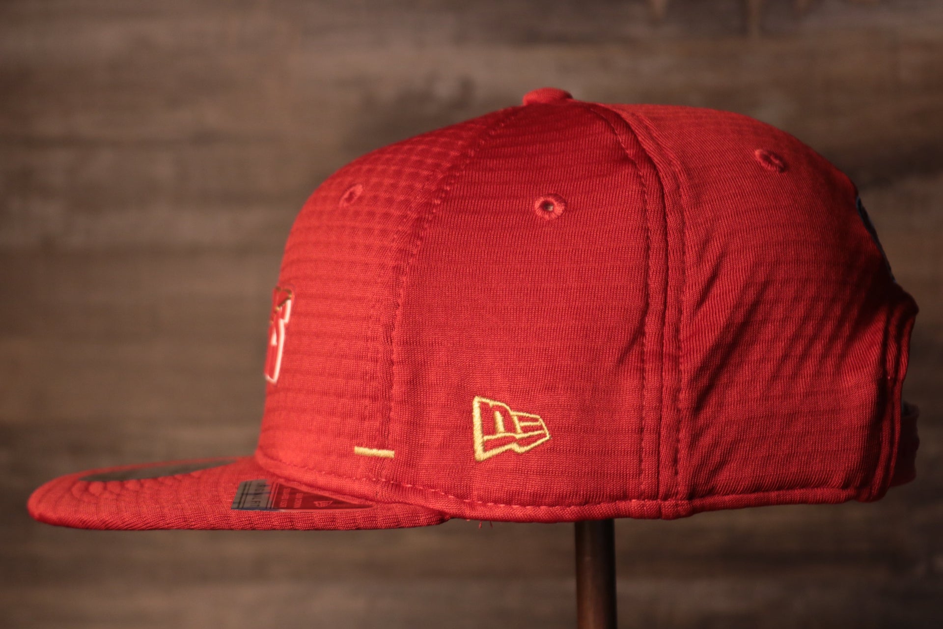The wearers left side has the new era logo 49ers 2020 Training Camp Snapback Hat | San Francisco 2020 On-Field Red Training Camp Snap Cap