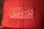 The 49ers name is red with an outline of gold and white 49ers 2020 Training Camp Snapback Hat | San Francisco 2020 On-Field Red Training Camp Snap Cap