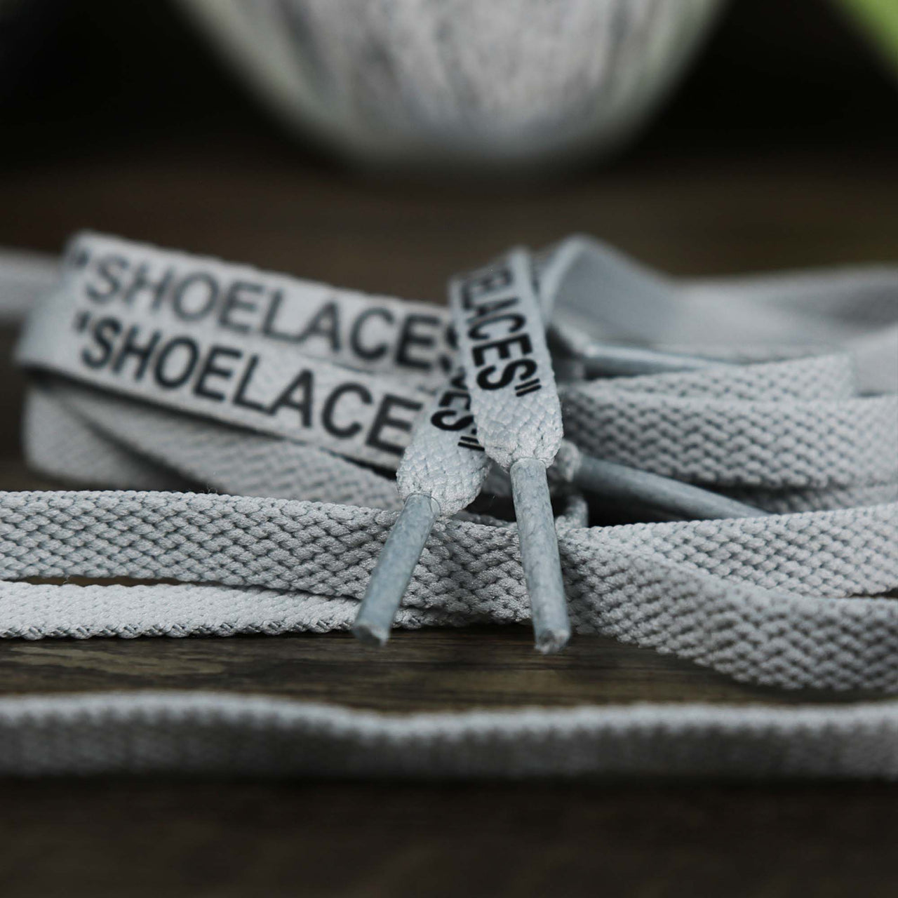 The aglets on the Flat Icey Grey Shoelaces with “Shoelaces” Print | 120cm Capswag