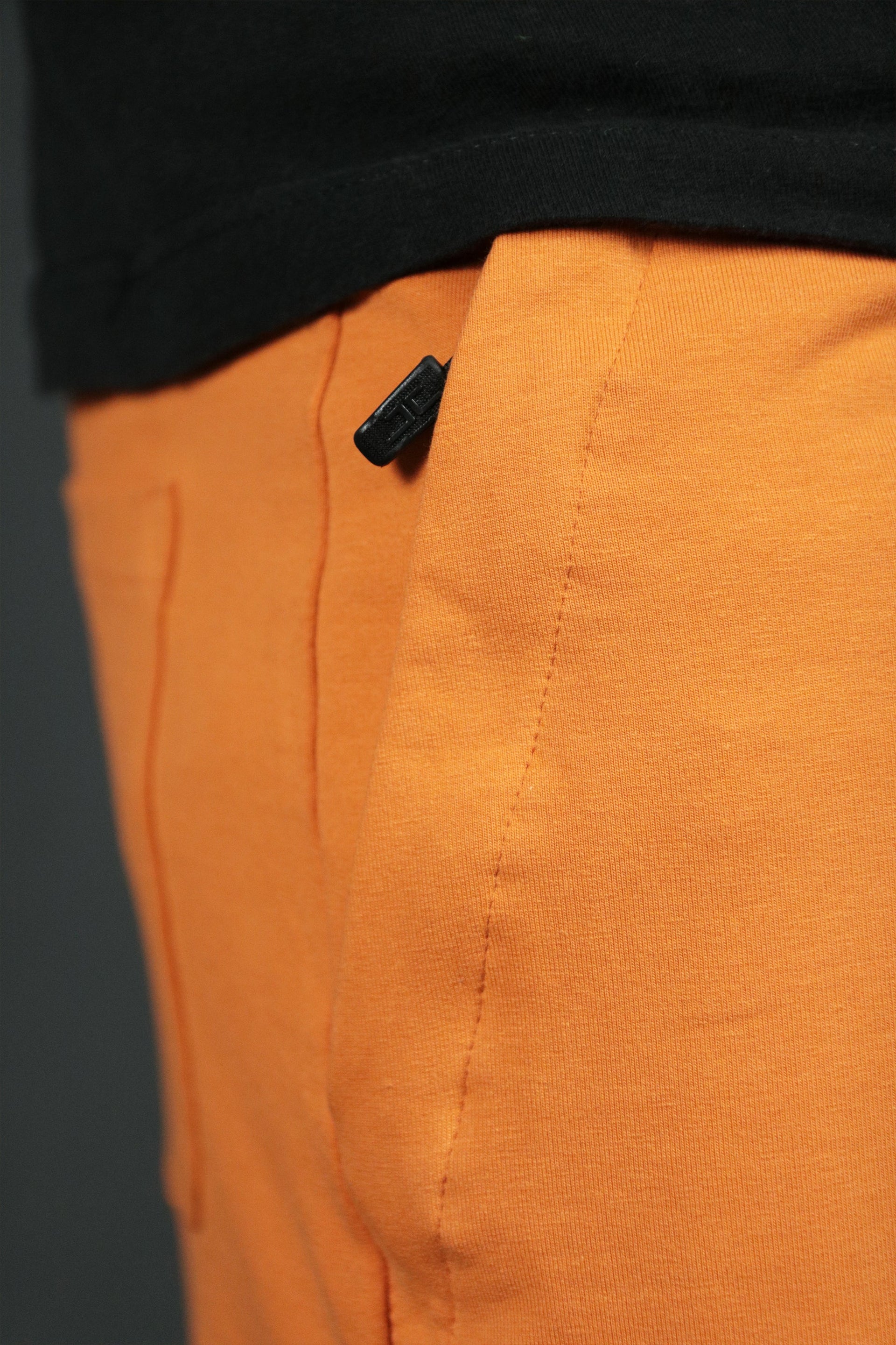 The zipped pocket of the orange mens terry cloth shorts by Jordan Craig.