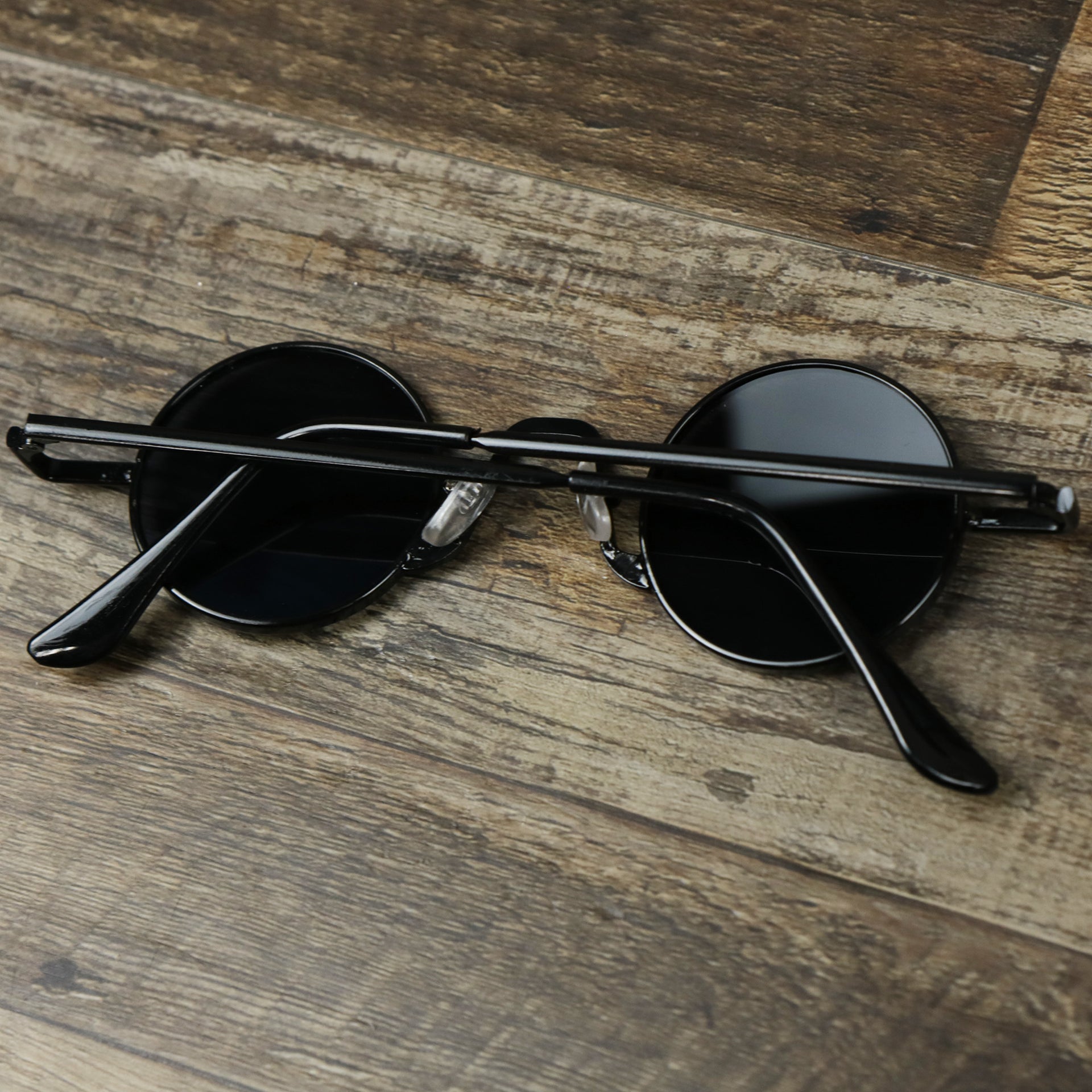The Round Frames Black Lens Sunglasses with Black Frame folded up