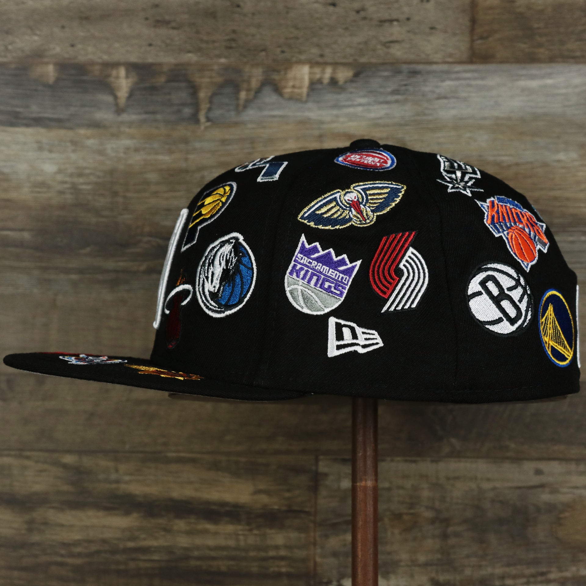 The wearer's left on the NBA Logo All Over patch fitted 59Fifty Cap with Gray Bottom | Black