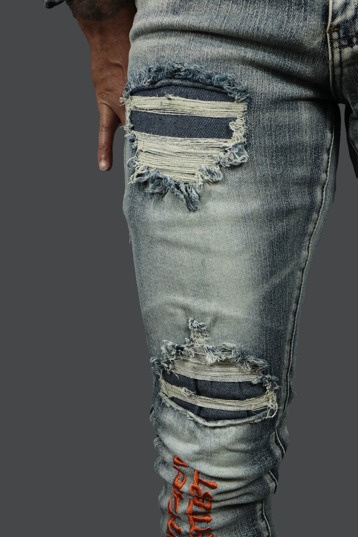 A close up of the holes on the Only The Strong Custom Spray Painted Distressed Denim Pants Motive Denim | Vintage |