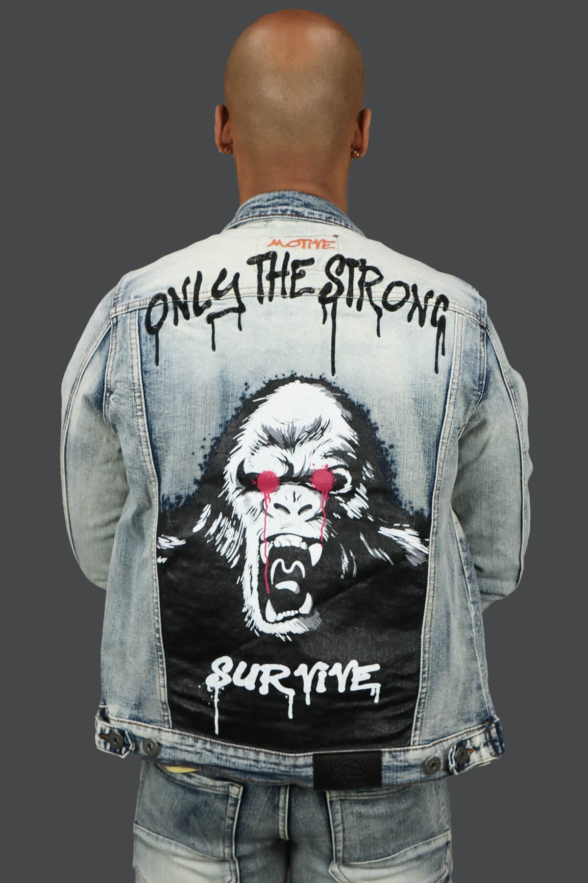 The back of the Only The Strong Custom Spray Painted Denim Jacket Motive Denim | Vintage | with the custom spray painted groilla ans spray painted words" Only The Strong Survive"