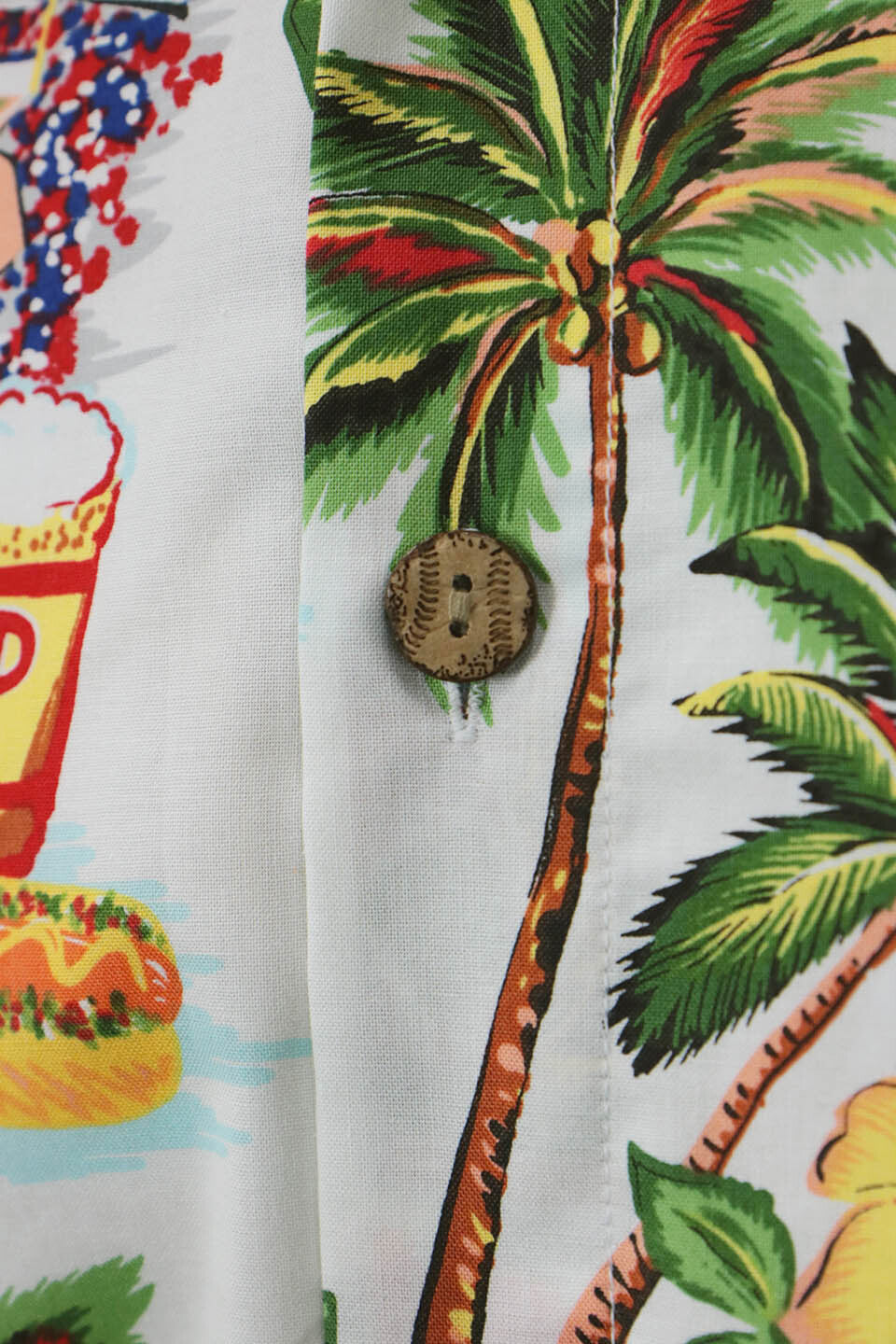 A close up of the custom laxer engraved wooden buttons on the Philadelphia Phillies Authentic Hawaiian Print Polo Shirt