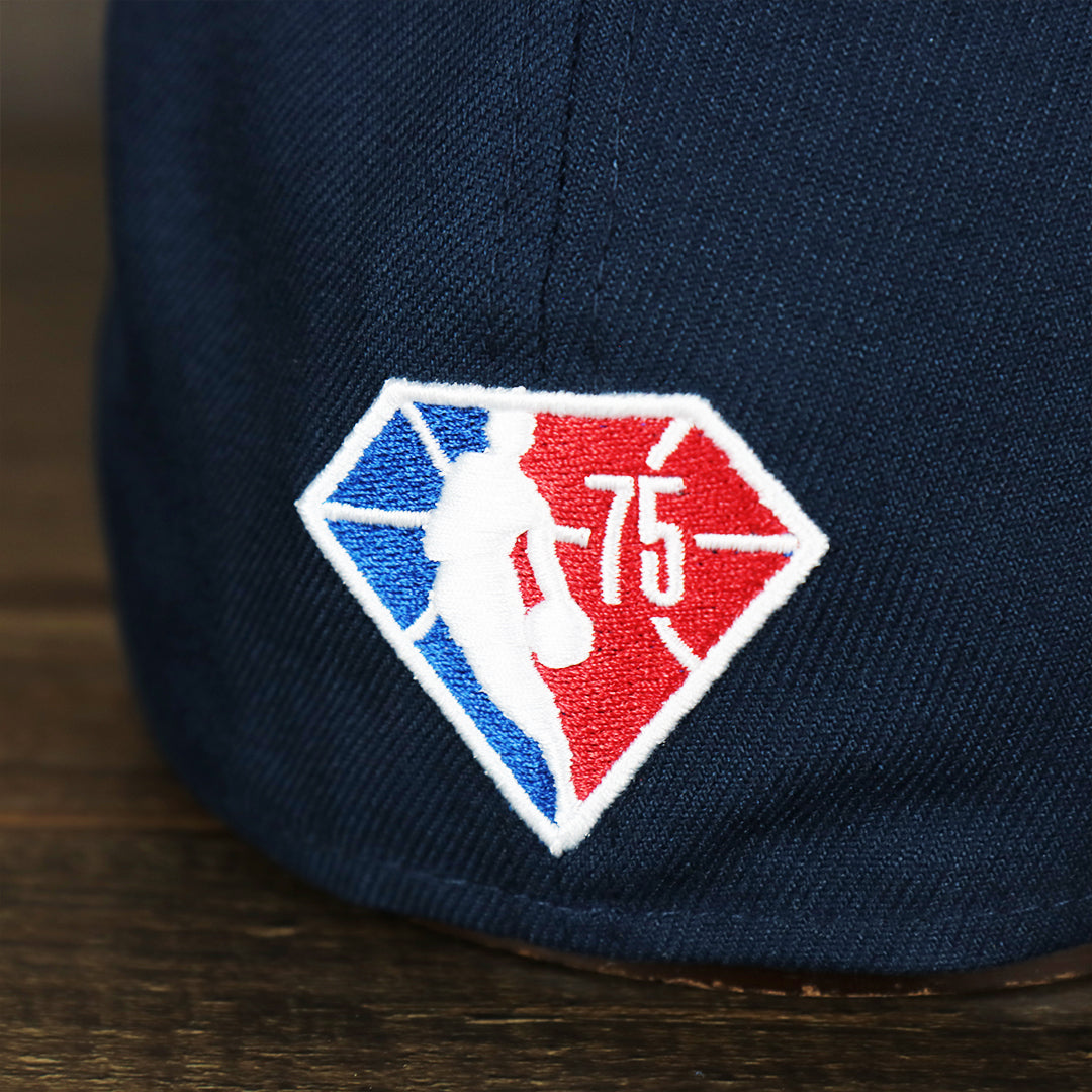 Close up of the diamond logo on the Philadelphia 76ers 2021 Retro Spectrum City Edition Gray Bottom 59Fity Fitted Cap | Navy