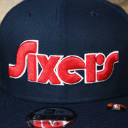 Sixers logo on the Philadelphia 76ers 2021 Retro Spectrum City Edition Gray Bottom 9Fifty Snapback | Navy