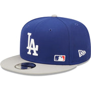 The wearer's left on the Los Angeles Dodgers Silver Letter Arch Retro Green Bottom 9Fifty Snapback Cap | Back Letter Arch Blue 9Fifty