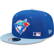 The wearer's left on the Toronto Blue Jays Cooperstown Green Bottom Light Blue Letter Arch 9Fifty Snapback Cap | Back Word Arch Royal Blue 9Fifty
